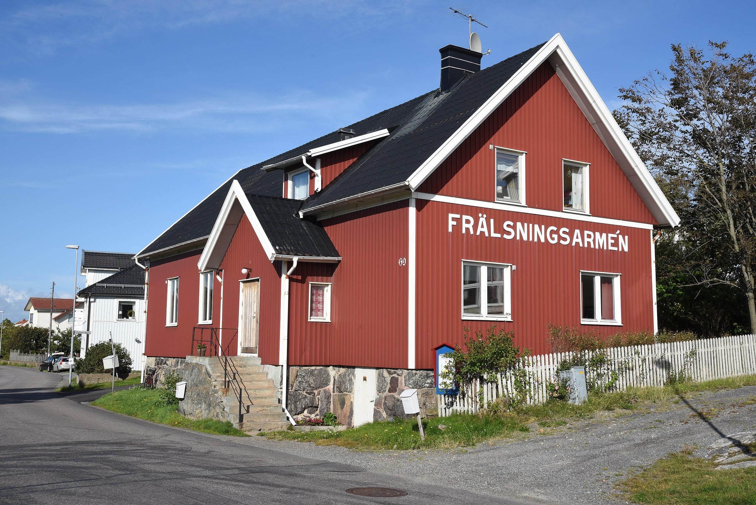 En röd villa i två våningar med namnet Frälsningsarmén i stora bokstäver på gaveln.