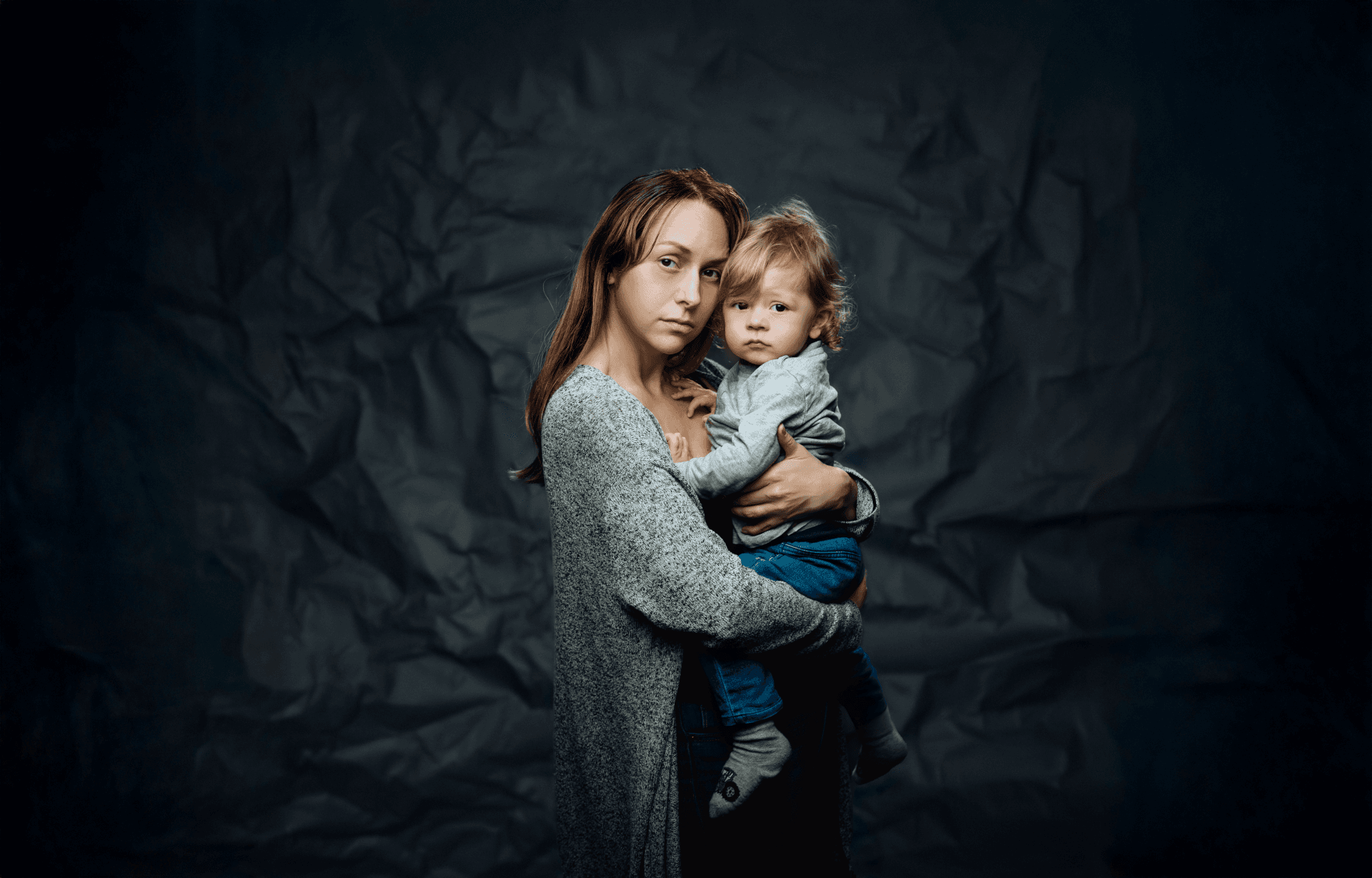 En utsatt ung kvinna med ett barn på ena armen